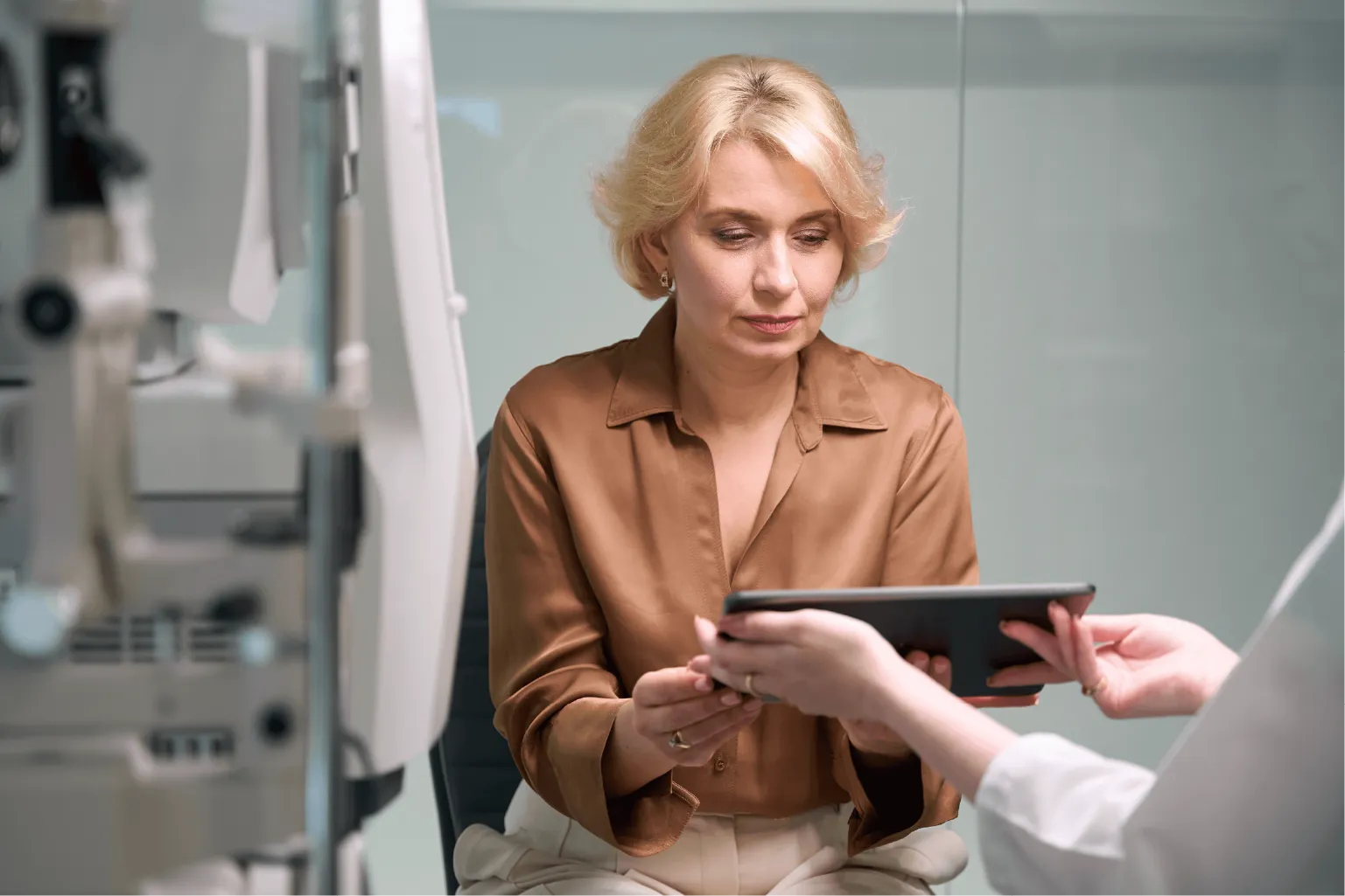 Eye surgeon explaining cataract surgery lens options and eye measurements to a patient during a friendly consultation